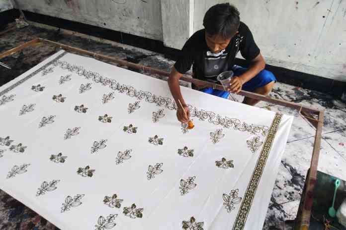 Seorang perajin melakukan pewarnaan kain batik khas Demak. (ANANTA ERLANGGA/JAWA POS RADAR SEMARANG)