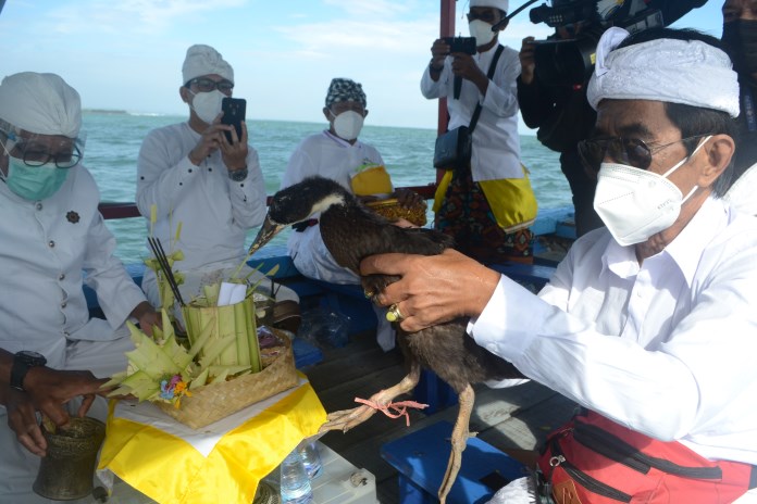 Umat Hindu melakukan ritual Melasti dengan melepas bebek dan mengambil air suci dari Pantai Marina Semarang (11/3/2021). (Nur Wahidi/Jawa Pos Radar Semarang)