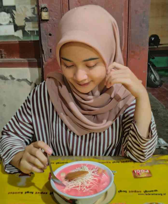 Erlina, salah satu pengunjung ketika menikmati es sekoteng Pak Woh, Jalan Kenanga, Kota Pekalongan Jumat (26/3/2021). (NANANG RENDI AHMAD/JAWA POS RADAR SEMARANG)