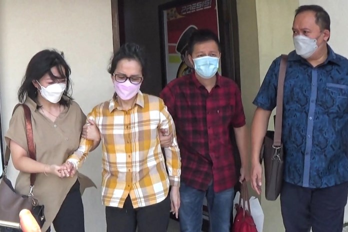 Meliana Widjaja digandeng dua anaknya, Tommy Widjaja, dan Olivia Grace, saat keluar dari ruang pemeriksaan Satreskrim Polrestabes Semarang. (M HARIYANTO/JAWA POS RADAR SEMARANG)