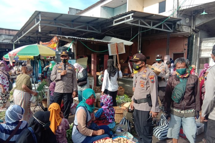 Kapolsek Tengaran Iptu Sungkowo dan Wakapolsek Iptu Wardoyo blusukan ke Pasar Kembangsari, Kecamatan Tengaran. Senin (8/3/2021). (Maria Novena/Jawa Pos Radar Semarang)