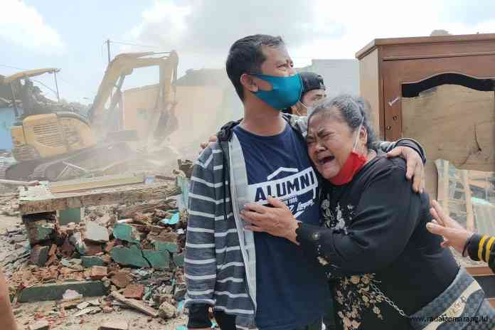 Seorang warga di eks pangkalan truk Banyuputih menangis meratapi kiosnya yang dibongkar paksa. Sebuah ekskavator merobohkan bangunan. (RIYAN FADLI JAWA POS RADAR SEMARANG)
