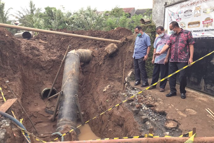 Direktur Teknis PDAM Kabupaten Semarang dan Direktur Teknis PDAM Kota Semarang mengecek karet pipa yang lepas di kawasan Mapagan, Ungaran Barat. Selasa (2/3/2021). (Maria Novena/Jawa Pos Radar Semarang)