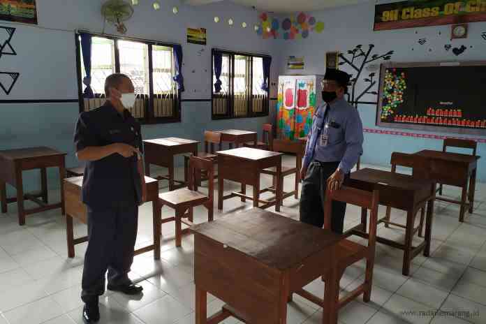 Kepala Disdikbud Aziz Amin Mujahidin bersama kepala SMPN 1 Mungkid Supriyanto memantau ruang kelas untuk uji coba PTM 5 April 2021. (LUQMAN SULISTIYAWAN/JAWA POS RADAR SEMARANG)