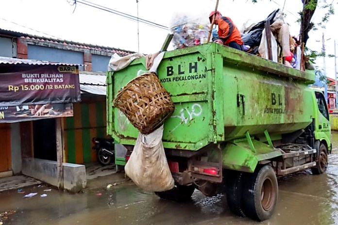 Petugas dari DLH Kota Pekalongan saat mengangkut sampah di wilayah banjir di Kota Pekalongan Senin (1/3/2021). (Lutfi Hanafi/Jawa Pos Radar Semarang)