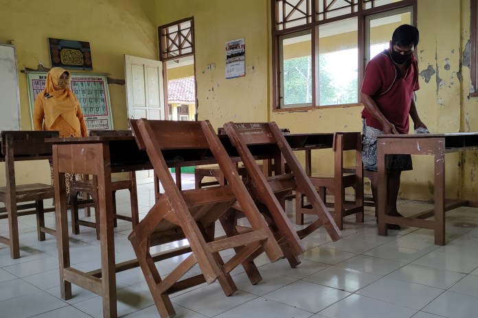 Kepala SD Negeri Menguneng 2 Kecamatan Warungasem Sri Hartati bersama petugas saat menyiapkan ruang kelas. (RIYAN FADLI/JAWA POS RADAR SEMARANG)