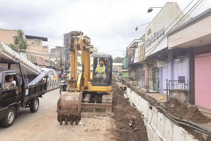 Pekerja menggali drainase dengan eskavator di Jalan Sudirman, Ambarawa, Selasa (9/3/2021). (TITIS ANIS FAUZIYAH/JAWA POS RADAR SEMARANG)