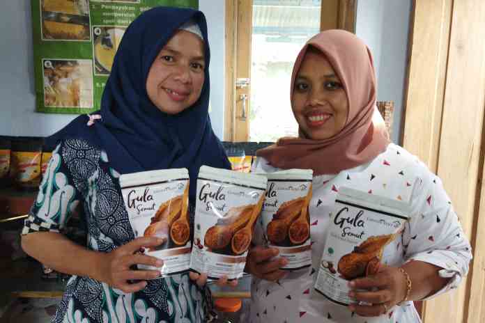 PRODUK EKSPOR: Susanti (kiri) menunjukkan gula semut yang sudah dikemas dengan merek Gendis Rejo. (RIRI RAHAYUNINGSIH/JAWA POS RADAR SEMARANG)