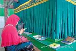 Salah seorang peziarah khusuk membaca Yasin, Tahlil, dan memohon keberkahan dari waliyullah. (PUTRI ISNAYNI/ JAWA POS RADAR SEMARANG)