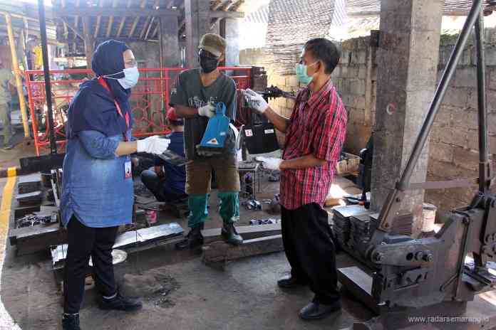 Koordinator Lembaga Pengembangan Bisnis Klaten, Yayasan Dharma Bhakti Astra (YDBA) Hafiza Dharmaputri (kiri) mendapat pejelasan dari Sekretaris Koperasi Industri Pande Besi dan Las, Supriyanto (kanan) tentang proses pembuatan cangkul.  (Istimewa)