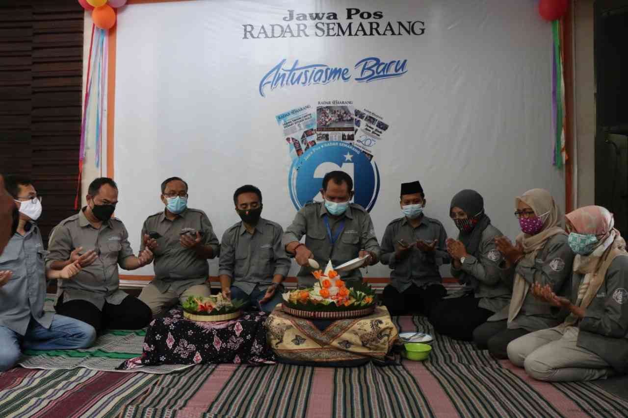 Direktur Jawa Pos Radar Semarang Baehaqi didampingi jajaran pimpinan saat memotong tumpeng HUT ke-21 Jawa Pos Radar Semarang. (NURCHAMIM/JAWA POS RADAR SEMARANG)