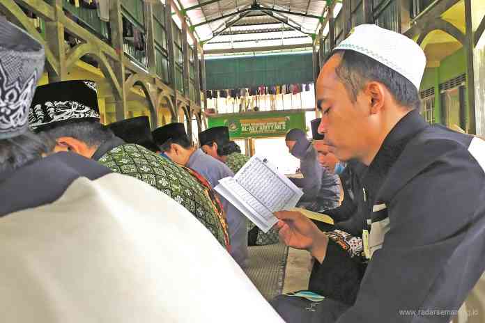 Sejumlah peziarah dan santri tengah khusuk berdoa dan melantuntkan ayat suci Alquran yang berada di komplek makam KH Muntaha Alh. (Sigit Rahmanto/Jawa Pos Radar Semarang)
