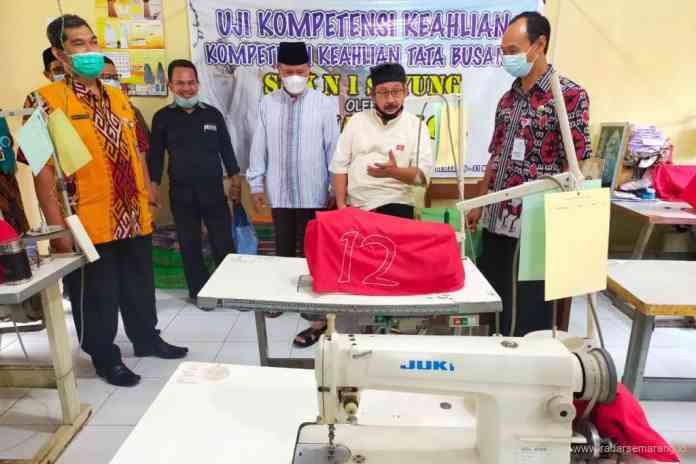 Kasi SMK Dinas Pendidikan Provinsi Jateng, Anon Priyantoro bersama Inisiator SMK Mbangun Desa, Gus Marlock dan Kepala SMKN 1 Sayung Santoso meninjau ruang keterampilan usai launching. (Wahib Pribadi/Jawa Pos Radar Semarang)