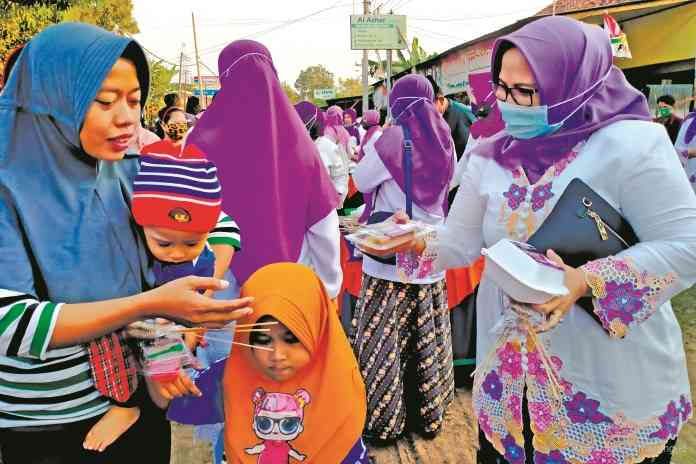 Ketua DPC Perempuan Bangsa sekaligus Ketua DPRD Kabupaten Pekalongan Hindun ketika membagikan takjil ke masyarakat di Jalan Raya Bojong Rabu (21/4/2021). (NANANG RENDI AHMAD/JAWA POS RADAR SEMARANG)