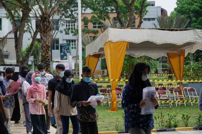 Peserta UTBK SBMPTN Unnes antri dan menjaga jarak sebelum memasuki ruangan ujian. (Istimewa)
