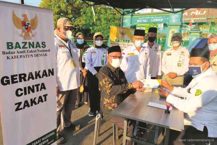 Bupati Demak HM Natsir bersama Ketua Baznas Demak Bambang Soesetiarto memberikan contoh gerakan cinta zakat. (Wahib Pribadi/Jawa Pos Radar Semarang)