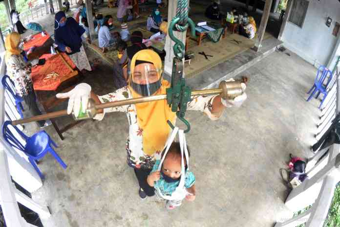 Tumbuh kembang balita akan dipantau di Posyandu. Balita akan ditimbang dan diukur tingginya untuk memastikan telah menerima cukup gizi dalam pertumbuhannya. (NURCHAMIM/JAWA POS RADAR SEMARANG)
