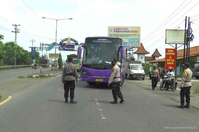 Sebuah bus pariwisata yang ketahuan mengangkut pemudik dipaksa putar balik ke Pekalongan saat akan masuk wilayah Kendal. (BUDI SETYAWAN/JAWA POS RADAR SEMARANG)