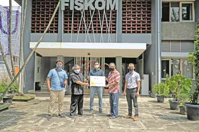 Dekan Fiskom Dr Royke R Siahainenia menyerahkan bantuan secara simbolis kepada perwakilan mahasiswa Fiskom asal NTT. (Dhinar Sasongko/Jawa Pos Radar Semarang)