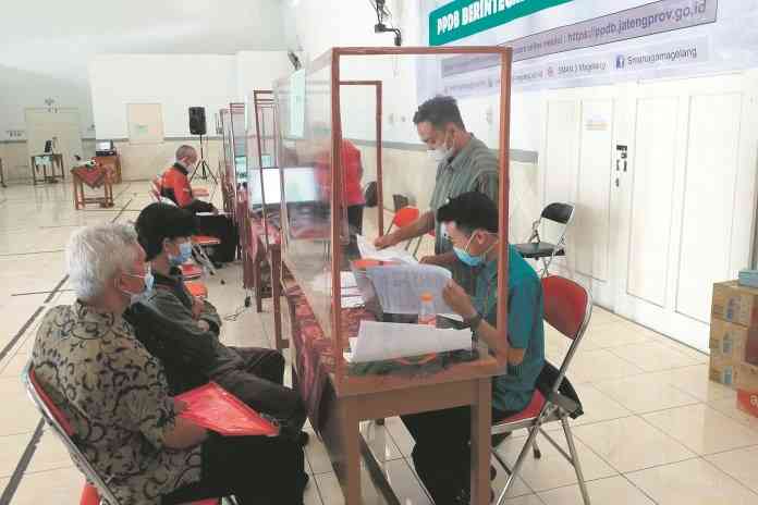 Calon peserta didik baru didampingi orang tuanya mendatangi layanan informasi PPDB 2021 di SMA Negeri 3 Magelang Selasa (22/6/2021). (ROFIK SYARIF G P/JAWA POS RADAR SEMARANG)