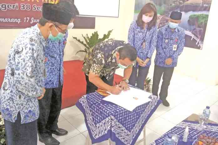 Wali Kota Semarang Hendrar Prihadi saat membubuhkan tanda tangan pada Naskah Deklarasi Sekolah Duta Wisata di SMP Negeri 38 Semarang, Kamis (17/6/2021). (ADIT BAMBANG SETYAWAN/JAWA POS RADAR SEMARANG)