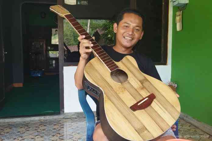 Mukhlis bersama gitar bambu buatannya. (RIRI RAHAYU/JAWA POS RADAR SEMARANG)