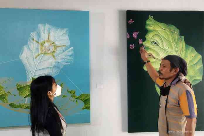 Nurfu Ad ketika menjelaskan karyanya kepada pengunjung pameran di studionya di Desa Tuksongo, Kecamatan Borobudur (19/7/2021). (RIRI RAHAYU/JAWA POS RADAR SEMARANG)