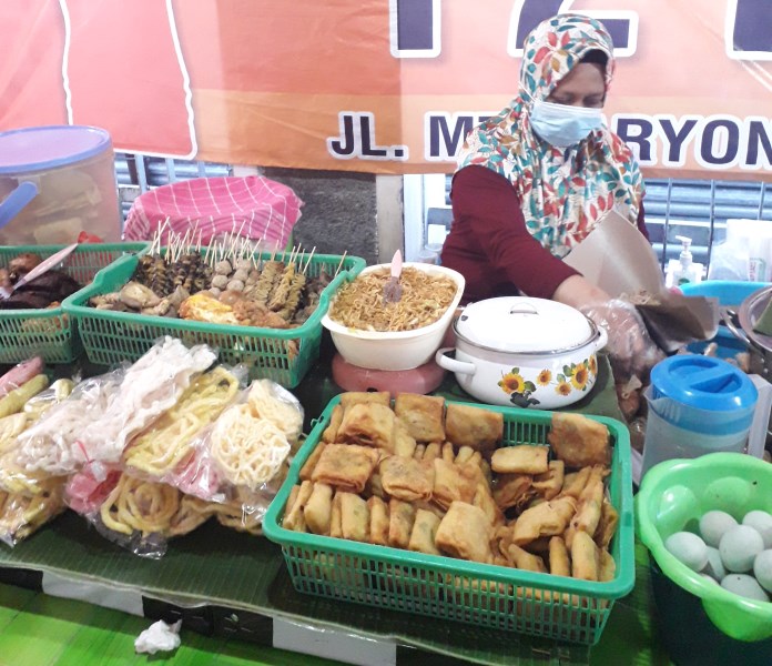 Nur Kholik, penjual nasi pecel F2 Mataram yang lokasinya di Jalan MT Haryono, Karangkidul, Kecamatan Semarang Tengah sedang membungkus nasi pecel pesanan pelanggan. (Maydi Hanivirgine/Jawa Pos Radar Semarang)