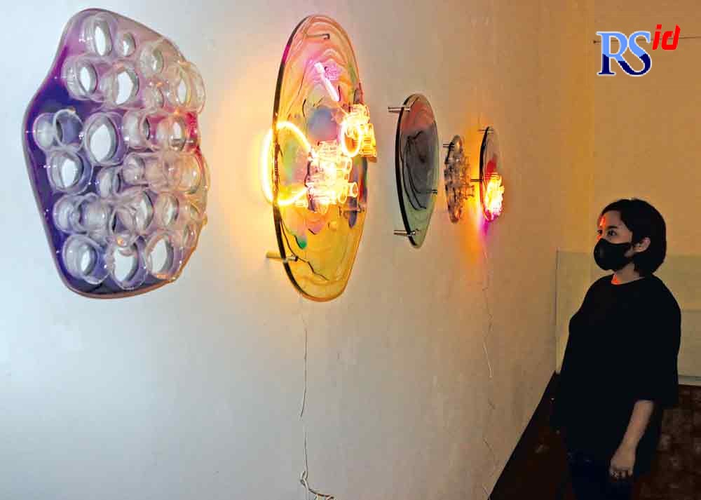 Kurator Ignatia Nilu mengamati salah satu karya dalam pameran seni rupa Sensing Sensation di Semarang Gallery Jumat (20/8/2021). (NUR CHAMIM/JAWA POS RADAR SEMARANG)