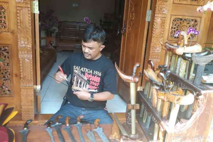 Pemerhati keris, Dekan Bawono sedang membersihkan kerisnya saat bulan Suro. (Dhinar Sasongko/Jawa Pos Radar Semarang)