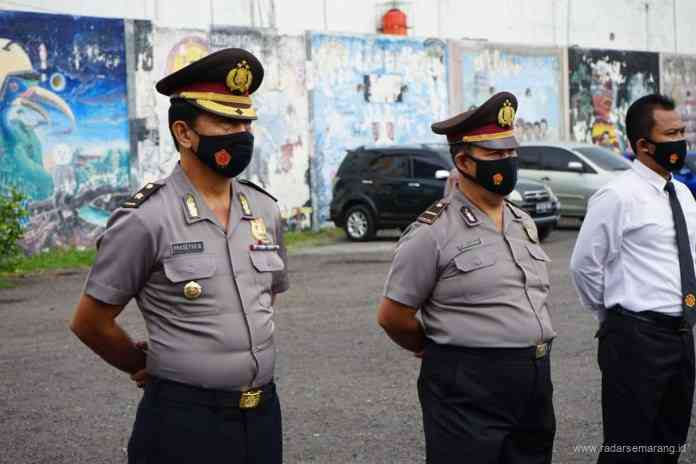 Kompol Prasetyo Budianto (kiri) dan Ipda Istiyono (kanan) menerima kenaikan pangkat pengabdian di halaman apartemen Musvia, Senin (2/8/2021). (ROFIK SYARIF G P/JAWA POS RADAR SEMARANG)