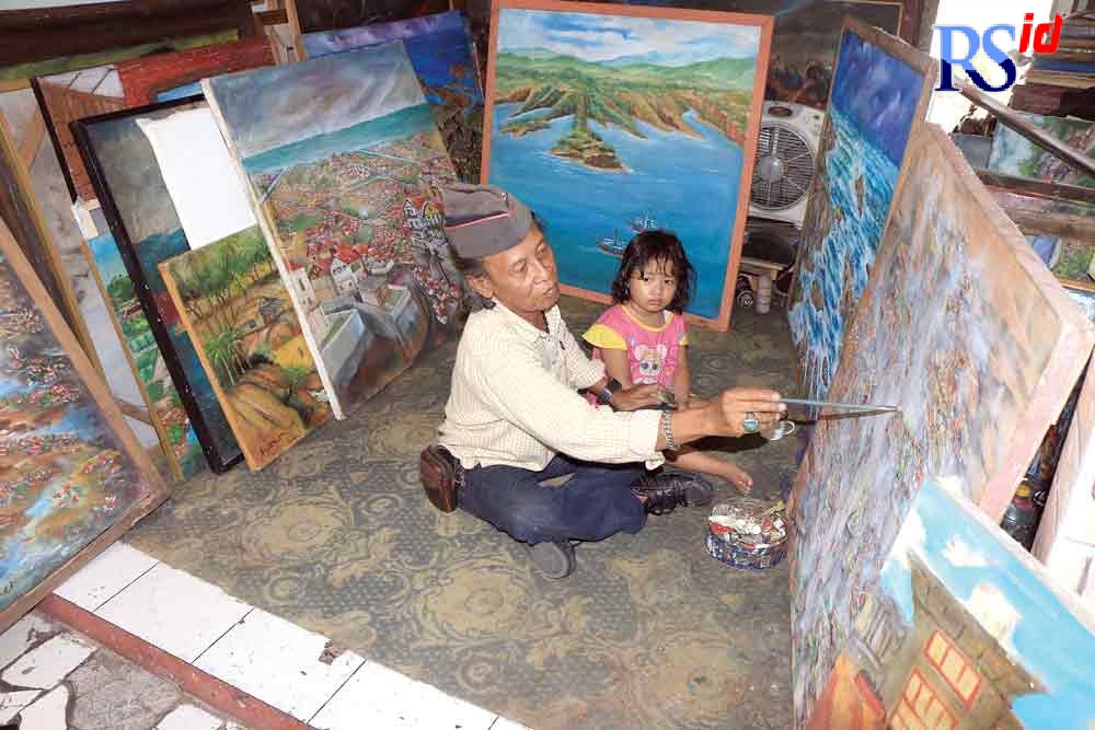 Pelukis Semarang Andreas Blontang menunjukkan karya lukisnya yang menggambarkan Semarang tenggelam di Sanggar Blontang Taman Budaya Raden Saleh Semarang. (NUR CHAMIM/ JAWA POS RADAR SEMARANG)