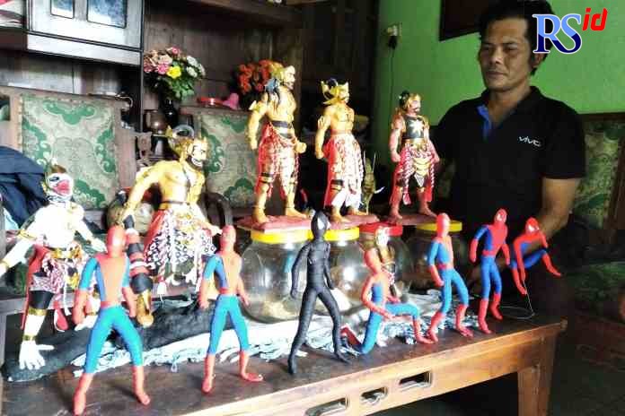 KREATIF: Wisnu Wijanarko menunjukkan patung karakter wayang dan tokoh hero yang dibuat dari bahan koran bekas dan bahan kain perca. (HAWIN ALAINA/ JAWA POS RADAR SEMARANG)