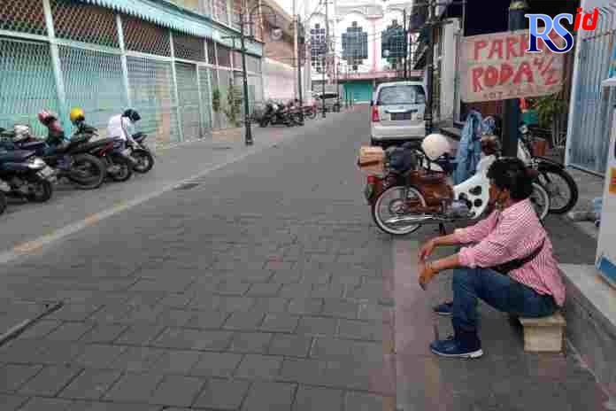 Juru parkir di Jalan Gelatik Kota Lama Semarang menjaga sepeda motor pengunjung. (DOKUMENTASI FIGUR RONGGO WASSALIM/JAWA POS RADAR SEMARANG)