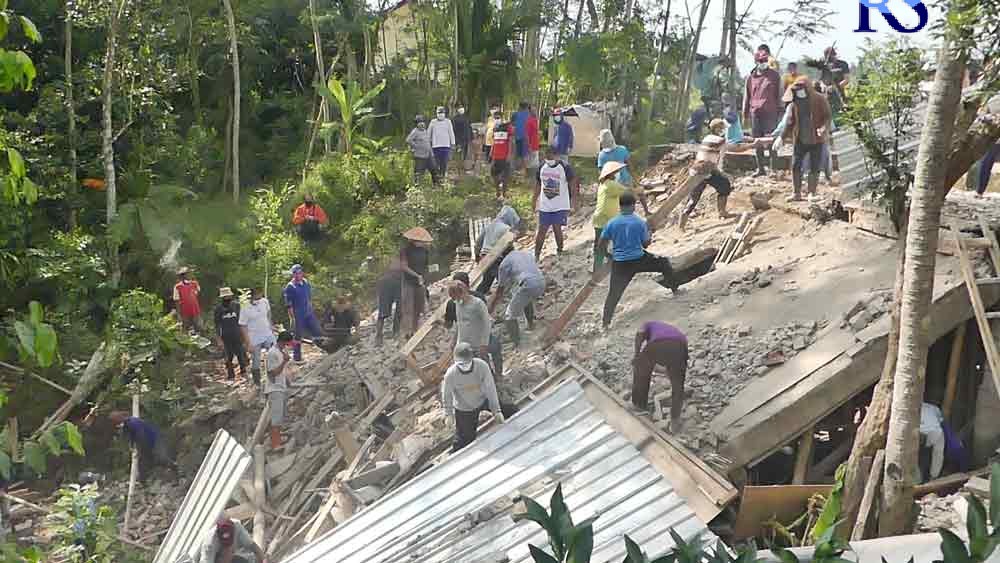 Warga Dusun Nogo, Desa Salamsari,  Kecamatan Kedu gotong-royong membersihkan puing rumah Kholiq Hidayat yang longsor pada Minggu (26/9/2021) malam. (ANANTA ERLANGGA MUSA / JAWA POS RADAR SEMARANG)