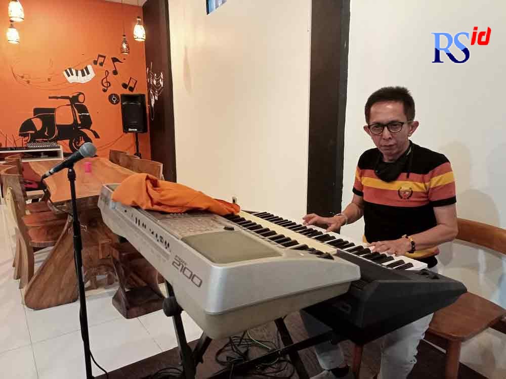 Sugijono atau Mas Sugi bermain piano di rumah makan miliknya Senin (6/9/2021). (ROFIK SYARIF G P/JAWA POS RADAR SEMARANG)
