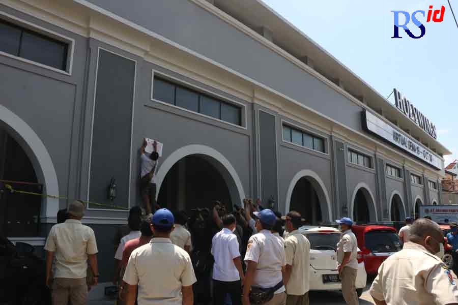 Petugas menyegel Holywings Semarang Rabu (27/10/2021) pagi. (Nurchamim/Jawa Pos Radar Semarang)