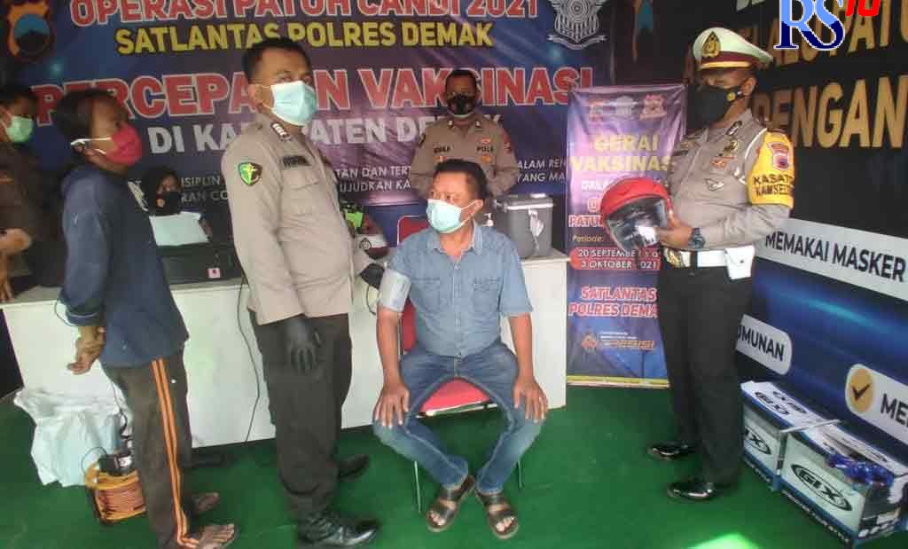 Kasatlantas Polres Demak AKP Fandy Setiawan memberikan helm kepada pengendara yang terjaring Operasi Patuh Candi di Pos Bogorame. (WAHIB PRIBADI/JAWA POS RADAR SEMARANG)