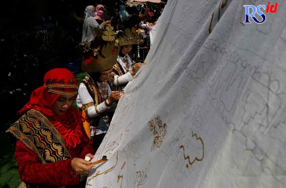 Para peserta Tatik Budayo mewarnai kain batik sepanjang 12 meter di Kampung Batik, Rejomulyo, Semarang Timur. (MURCHAMIM/JAWA POS RADAR SEMARANG)