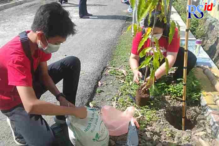 CINTA LINGKUNGAN : Sebanyak 18 wali siswa bersama siswa  menanam pohon  dalam memperingati HUT SMP Negeri 42 Semarang di tepi Jalan Pekuncen, Kelurahan Sendangmulyo, Kecamatan Tembalang, Jumat (8/10/2021). (ADIT BAMBANG SETYAWAN/JAWA POS RADAR SEMARANG)