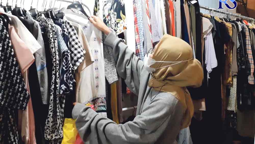 Seorang pengunjung tengah memilih-milih baju di acara Weekend Thrift 1St Sary di Up Uptree Coffee & Stories Semarang, Jalan Kawi Raya Kota Semarang Minggu lalu (3/10/2021). (ANIK MEILINDA/JAWA POS RADAR SEMARANG)