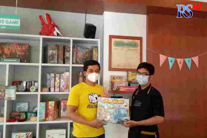 Ardiawan Bagus Harisa menunjukkan jenis game yang dia tawarkan bagi pengunjung Kafe Dhadu. (BAGAS TIMUR LASTOMO/JAWA POS RADAR SEMARANG )
