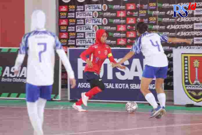 Pemain Guyub Rukun Angels dengan seragam warna putih biru mengejar pemain Srikandi Kota Wali Demak dalam pertandingan pertama Liga Futsal Nusantara (LFN) Jateng 2021. (AFP Jateng)