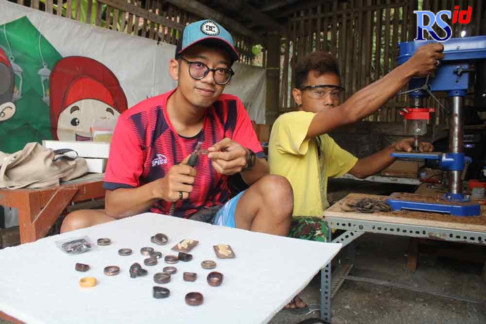 Yusuf dan Heri ketika tengah membuat cincin dari limbah batok kelapa di kediamannya Minggu (3/10/2021). (RIRI RAHAYU/JAWA POS RADAR SEMARANG)
