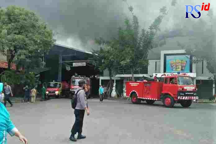 Pemadam kebakaran dibantu dua water canon Polri mencoma mengatasi kebakaran hebat di pabrik kacang dua kelinci. (Istimewa)