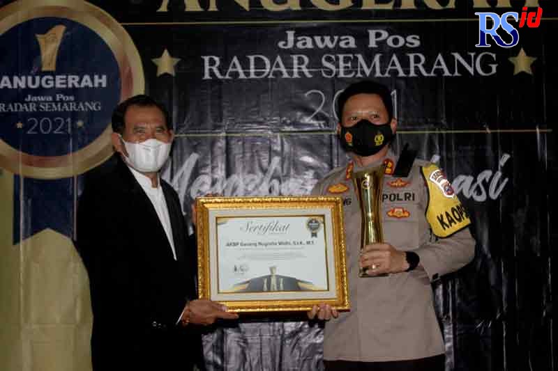 Kapolres Wonosobo AKBP Ganang Nugroho Widhi, S.I.K., M.I.K. saat menerima penghargaan dari Direktur Jawa Pos Radar Semarang Baehaqi Kamis (23/12). (ROFIK SYARIF GP/JAWA POS RADAR SEMARANG)