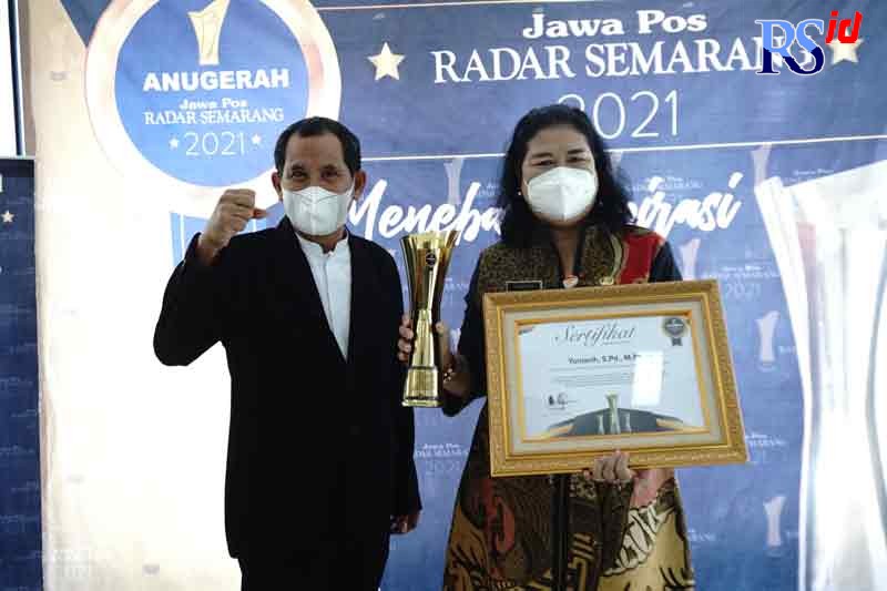 Direktur Jawa Pos Radar Semarang Baehaqi menyerahkan penghargaan Anugerah Jawa Pos Radar Semarang 2021 kepada Kepala SMAN 1 Kendal Yuniasih. (BUDI SETIYAWAN/JAWA POS RADAR SEMARANG)