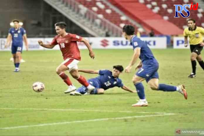 BEK : Bek tim nasional Indonesia Asnawi (kiri) menggiring bola melewati pemain Thailand Bordin Phala dalam laga leg pertama final Piala AFF 2020 di Stadion Nasional, Singapura, Rabu (29/12/2021). Indonesia kalah 0-4. (Antara/HO/PSSI)