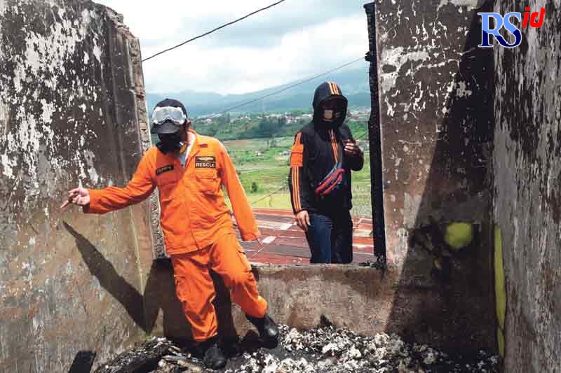Petugas mengecek puing-puing bekas rumah terbakar, kemarin (28/12) di Dusun Gintung, Desa Tegalsari, Garung. (Istimewa)