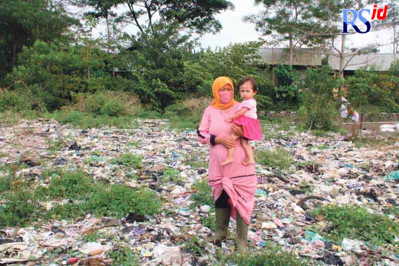 Salah seorang ibu menggendong anaknya saat melintas di TPA Sanggrahan. (ANANTA ERLANGGA MUSA/JAWA POS RADAR SEMARANG)